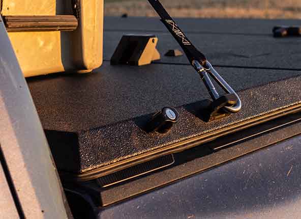 A ratchet strap hooked to the front cover cleat