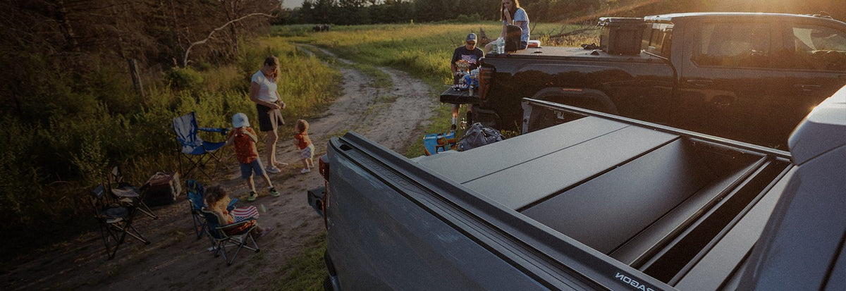 GMC Sierra with a Tectonic tri-fold tonneau cover at a campsite