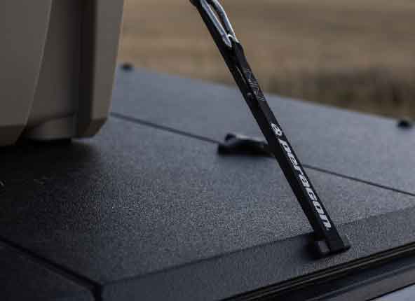 A ratchet strap hooked to the rear cover cleat.